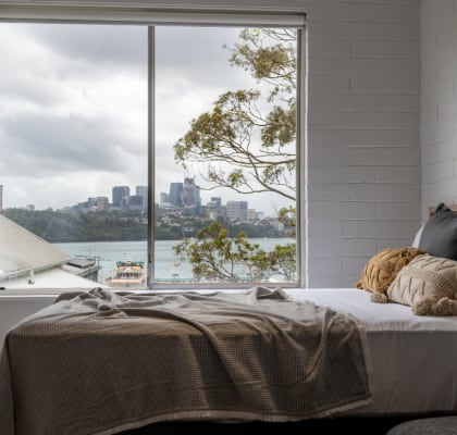 a bedroom with a bed and a window with a view of the city