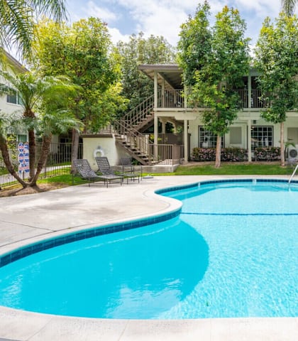 A large swimming pool in front of a house.