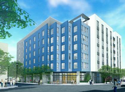 A blue and white building with people walking around it.