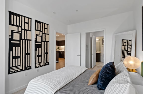 A bedroom with a large bed and two black and white artworks on the wall at The Parker Apartments in Portland, 97209
