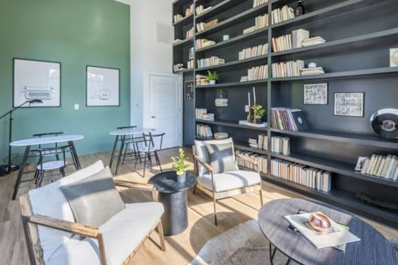 A living room with a green wall and a bookshelf filled with books.