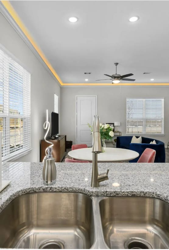 a kitchen with a sink and a view of a living room