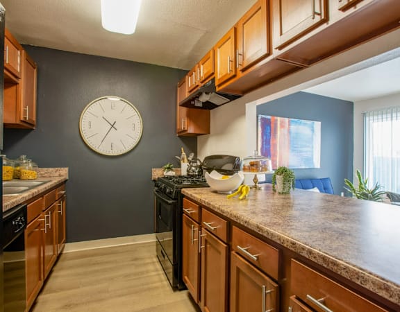A kitchen with wooden cabinets and a black stove top oven.