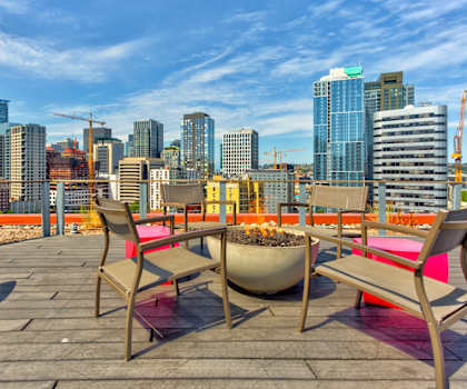 a roof deck with a fire pit and a view of the city