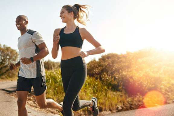 a man and a woman running down a road