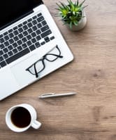a laptop and a cup of coffee on a wooden desk