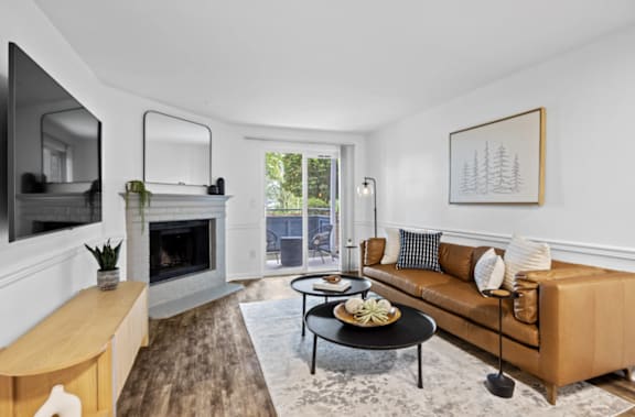 A living room with a brown couch and a fireplace at 2000 Lake Washington Apartments in Renton, Washington