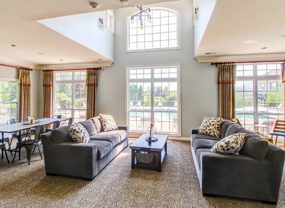 A living room with grey couches and a large window.