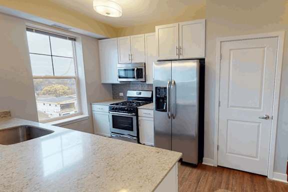 A kitchen with a washing machine in the doorway.