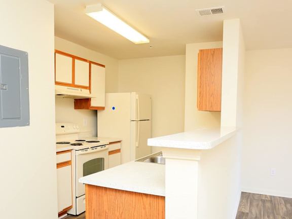 A kitchen with white appliances and wooden cabinets. at The Regency, Manassas, VA, 20109