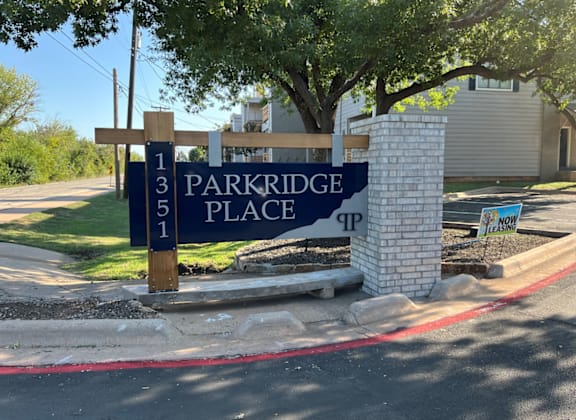 A sign for Parkridge Place is displayed in front of a building.