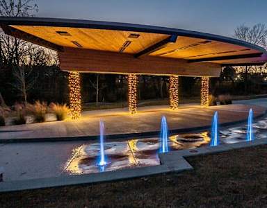 A pavilion with a circular walkway and lights underneath it.