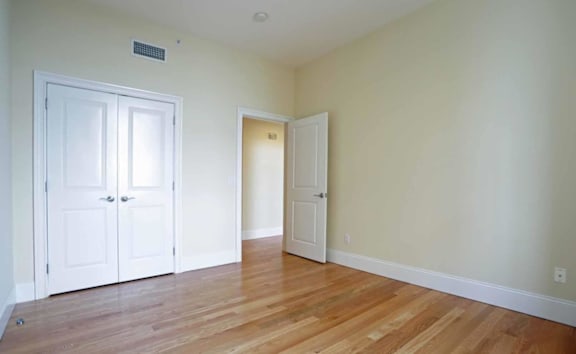 A room with a white door and a white cabinet.