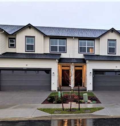 A large house with a grey roof and a brown door.