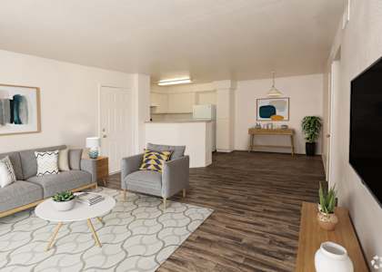A living room with a grey couch, a white coffee table, and a grey armchair.