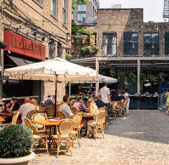 A restaurant with people sitting at tables outside.
