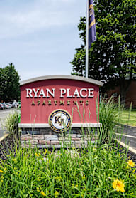 A sign for Ryan Place Apartments is in front of a building.