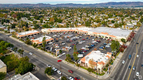 A parking lot is surrounded by buildings and roads.