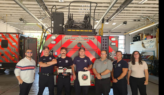 A group of people in front of a fire truck.