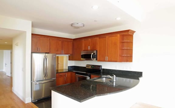 A kitchen with wooden cabinets and a black countertop.