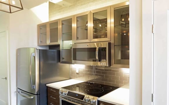 A kitchen with a stainless steel refrigerator and microwave ovens.