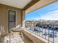 a balcony with a table and chairs overlooking a parking lot at Willow Creek, Kansas City, 64114