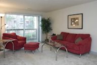 a living room with a red couch and chair and a sliding glass door at Waldo Heights, Kansas City, 64131