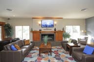 A living room with a brown couch and a fireplace. at The Bridges at Foxridge, Kansas, 66202