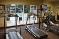 A gym with treadmills, elliptical machines, and a television. at The Bridges at Foxridge, Kansas, 66202