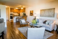 A living room with a grey couch and a coffee table. at Marine View Apartments, Alameda, CA