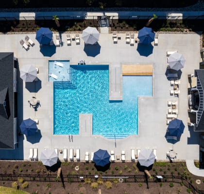 an aerial view of a large blue pool with umbrellas and chairs around it
