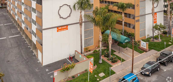 an aerial view of a building with palm trees in front of it
