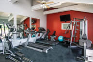 A gym with a variety of equipment including treadmills, elliptical machines, and a weight bench. at Lansing Riverwood, LLC, Lansing, 60438