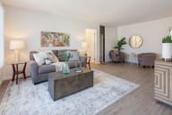 A living room with a grey couch, a coffee table, and a rug. at Three Crown Apartments, California, 94501