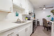 A kitchen with white cabinets and a wooden floor. at Marine View Apartments, Alameda, CA