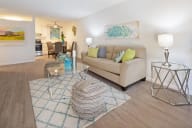 A living room with a couch, a chair, a table, and a rug. at Marine View Apartments, Alameda, CA