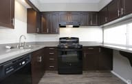 A modern kitchen with dark brown cabinets and a black oven. at The Township, Missouri