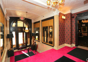 the lobby of a hotel with a pink carpet and a large door at York House, Saint Louis, MO