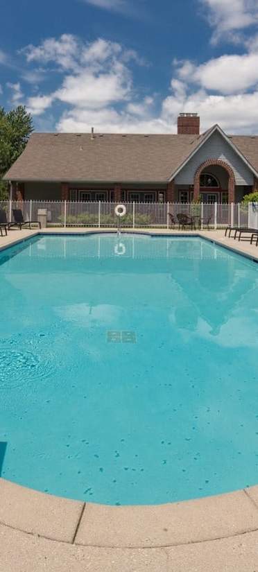A large outdoor swimming pool surrounded by lounge chairs.