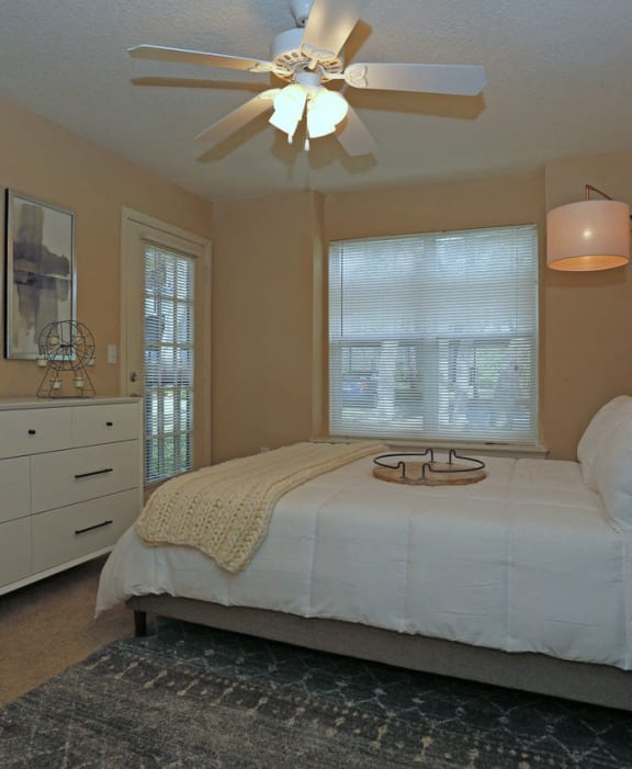 Bedroom with large window and ceiling fan