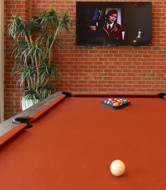 A pool table with a white ball in the middle of it.