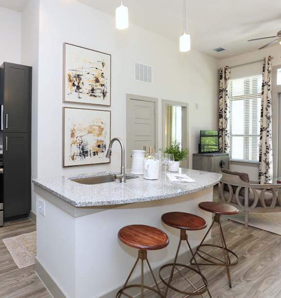 Modern apartment in Marietta, GA with granite counters, kitchen island, and stainless steel appliances.