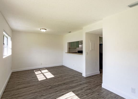 an empty living room with white walls and wood flooring