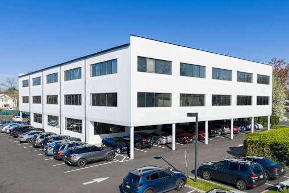 A white building with a parking lot in front of it.