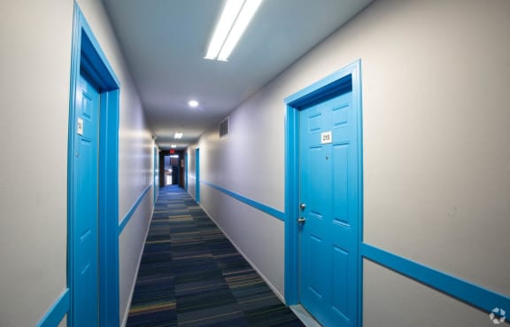 a hallway with blue doors in a building
