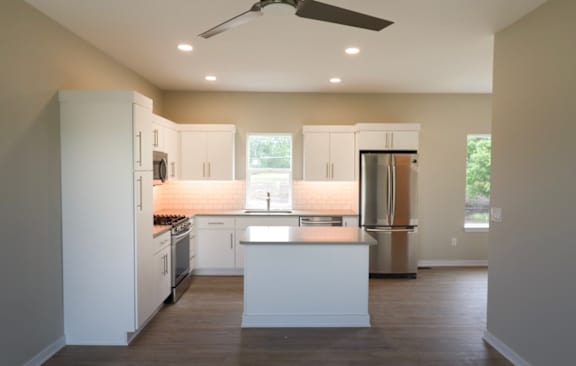 A modern kitchen with white cabinets and stainless steel appliances.