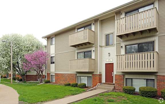 Apartment building with a tree in bloom in front. at Kimberly Club Apartments, Davenport, Iowa
