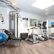 a gym with treadmills and other exercise equipment in a room with a mirror