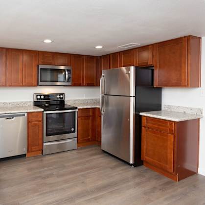 a kitchen with wooden cabinets and stainless steel appliances