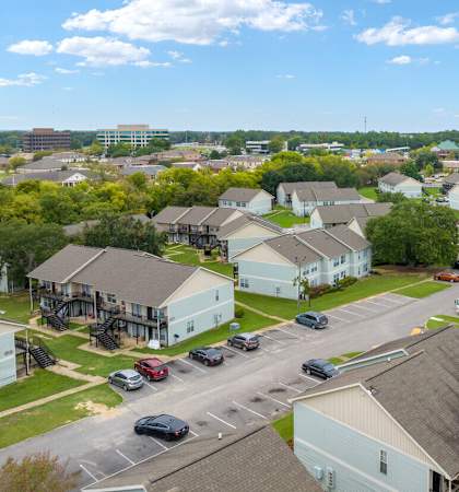 A view of a housing complex with a parking lot in the foreground.